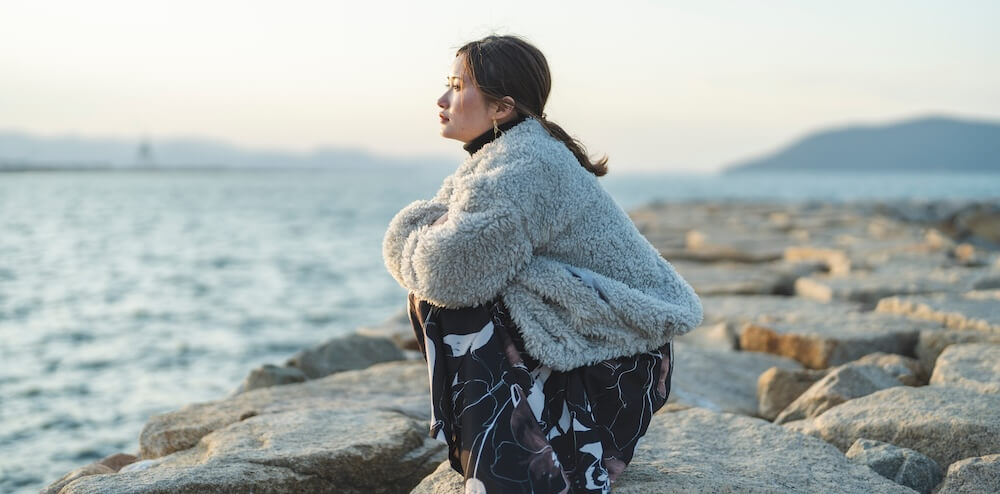 夕暮れの海にいる女性